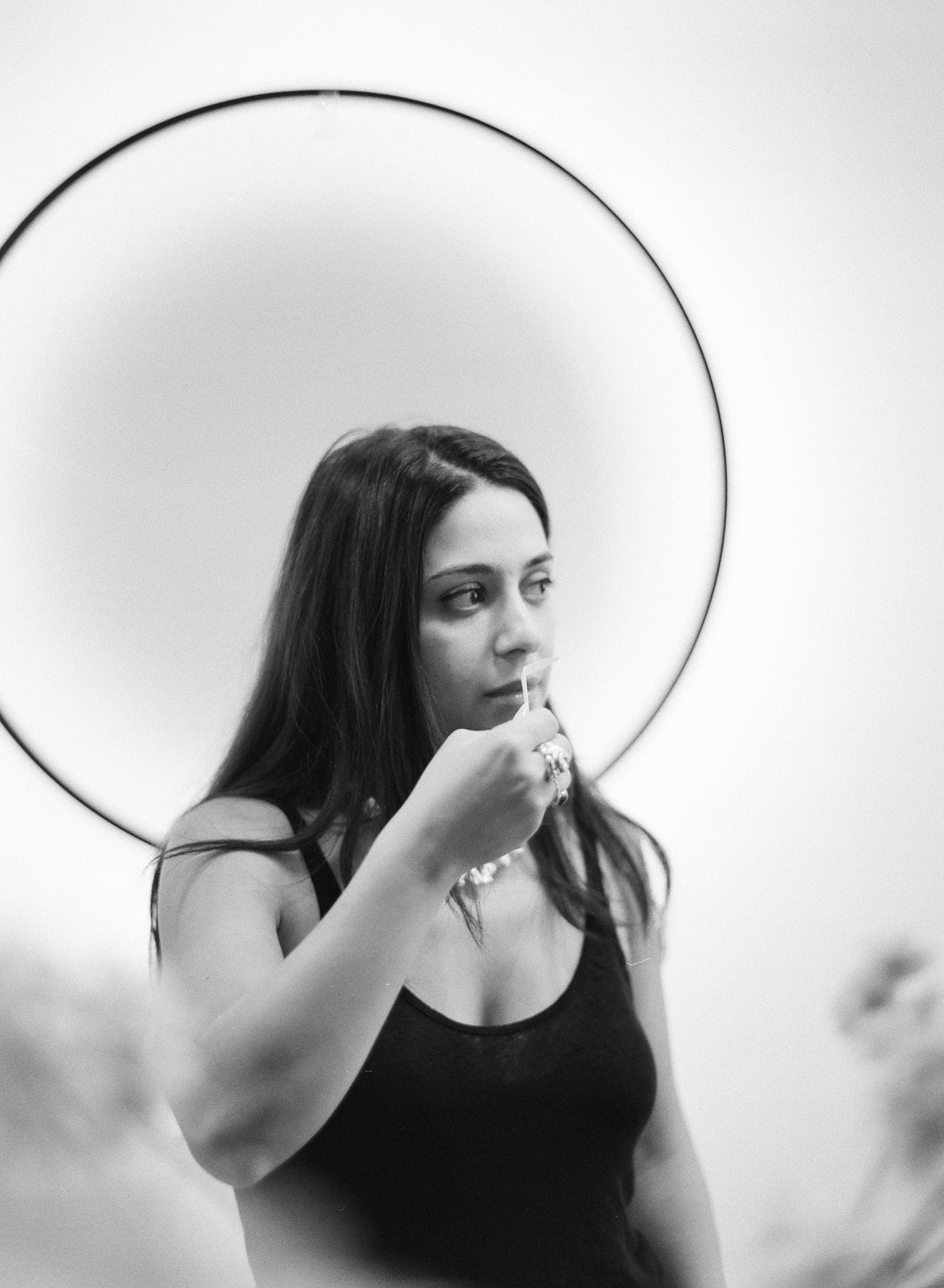 Black-and-white portrait of Mabelle smelling a scent strip